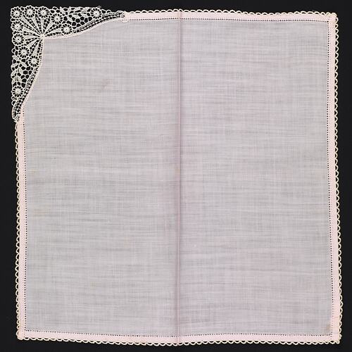Unfolded pink handkerchief with lace corner.