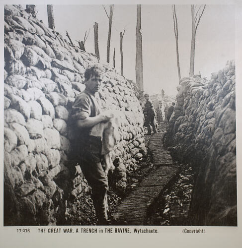 Front of photograph showing man in sandbagged trench.