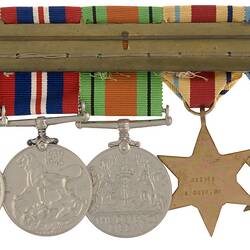Group of five metals with ribbons joined together by metal pin.