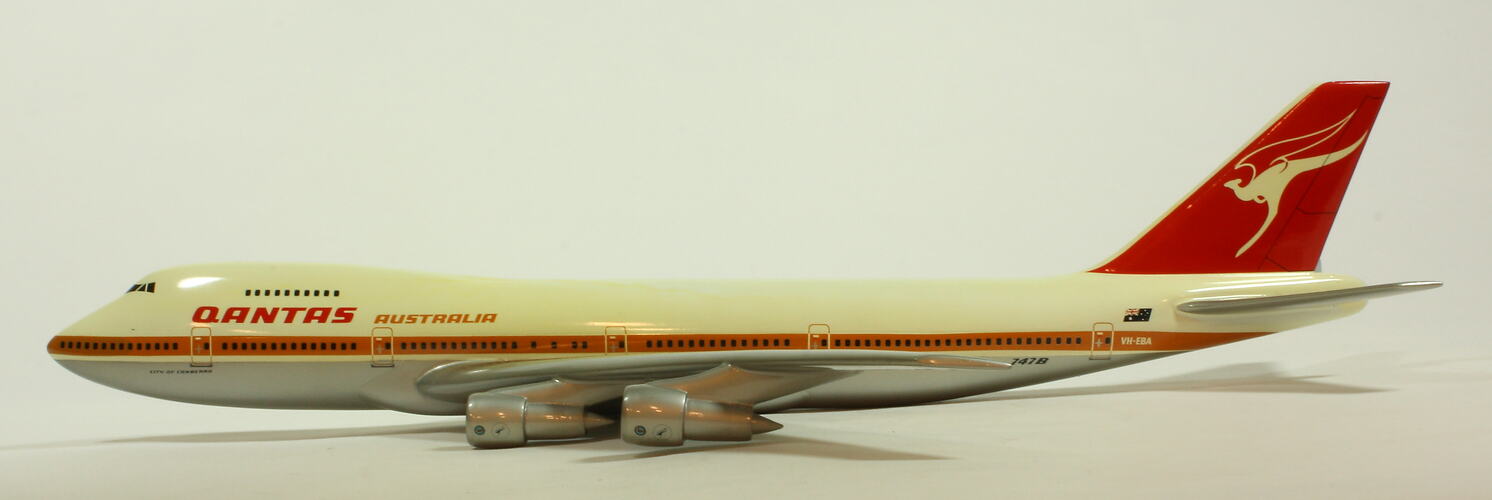 White model plane with red trim and tail. Grey wings. Left profile.