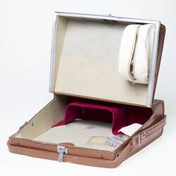 Open tan leather carry case with leather hand strap. Cream lining and zipper case within.