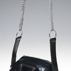 Black leather cylindrical shoulder-strap bag with metal zip across top and right side.