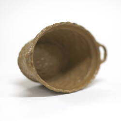 Side view of tiny metal laundry basket showing interior.