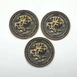 Three identical round patterned paper plates.