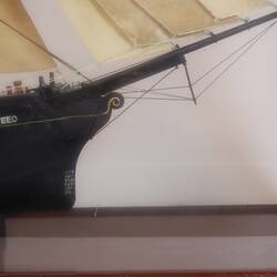 Detail of sailing ship model in glass case, facing right.
