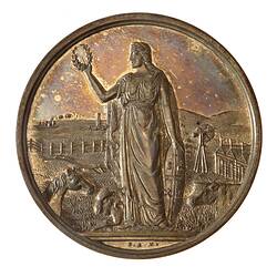 Medal with Victoria holding up a wreath and left hand on a shield. Farm animals at her feet, ships in distance