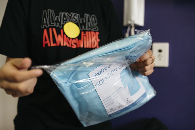 Staff Member Opens Covid Testing Surgical Gown at First Peoples Health and Wellbeing Clinic, Thomastown, Wurundjeri Woi Wurrung Country, Victoria, 25 Mar 2021
