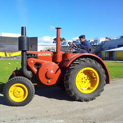 Left side view, tractor driving around arena.