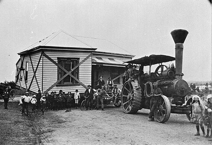 [A steam tractor moving a house at St Arnaud, about 1915. The house is supported by diagonal struts.]