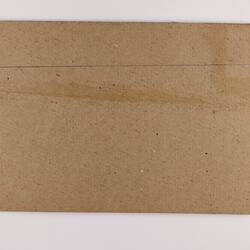 Plain back of a brown exhibition label.