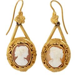 Pair of decorative gold mounted cameo earrings. The matched cameos are of a classical woman's profile with cloth draped over the shoulder and with a ringlet of hair falling behind an ear. One profile faces right, the other, left.