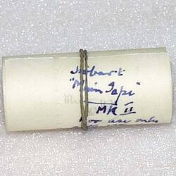 Rolled paper tape with blue handwriting on it.