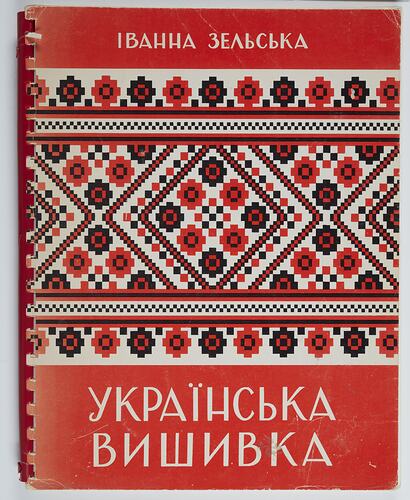 Spiral bound red book cover with white Ukrainian text and geometric patterned design.