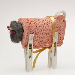 Toy sheep made from folded orange dishwashing sponge, steel wool ball, matches, white pegs.