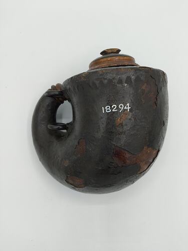 Rounded gun powder flask, wood covered with papier-mache. Wooden stopper & two rings for carriage.