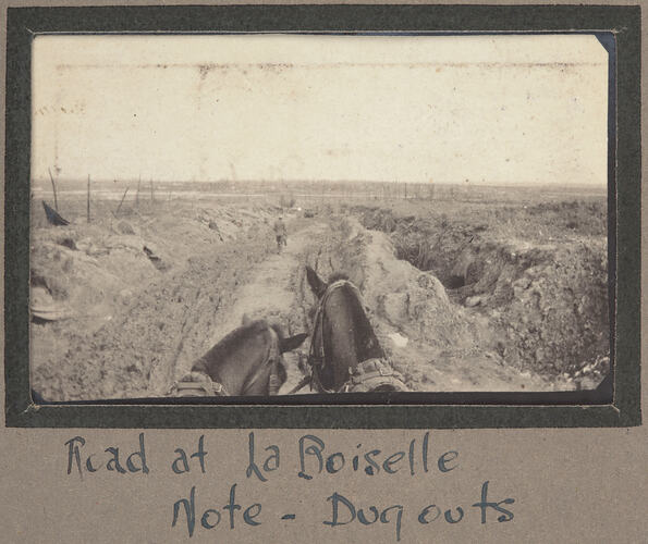 View of a dugout and a destroyed landscape, as seen from the view of a passenger on a horse drawn cart.