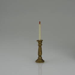 Gold coloured candle stick and white candle