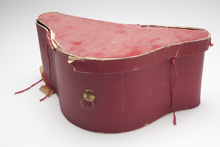 Battered red hat-box with brass fitting