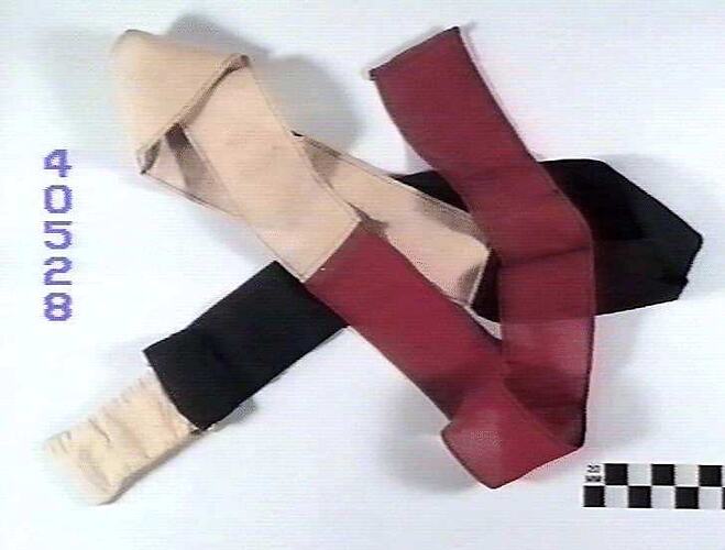 Partly folded length of red, white and black fabric.