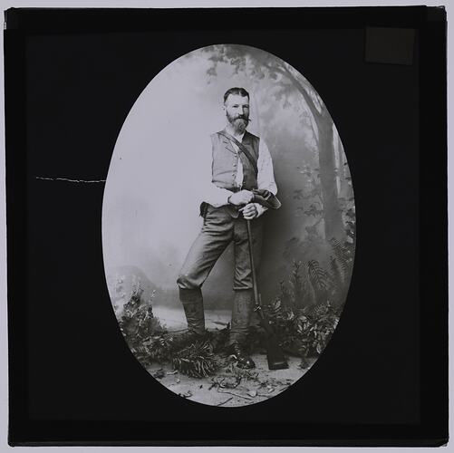Bearded man holding a rifle.