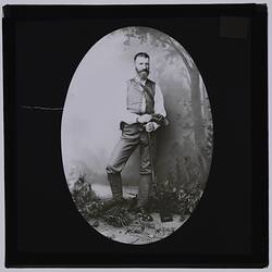 Bearded man holding a rifle.