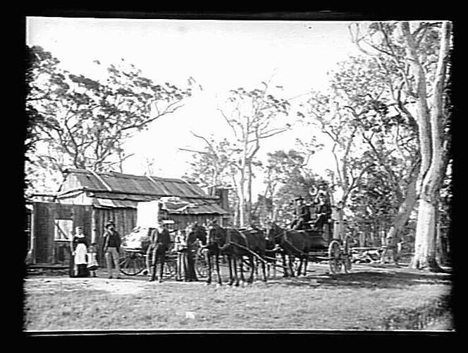 Slab hut, people and horse-drawn vehicles.