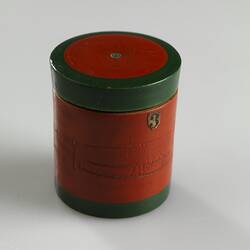 Red painted, cylindrical wooden box. Dark green trim around lid and base.