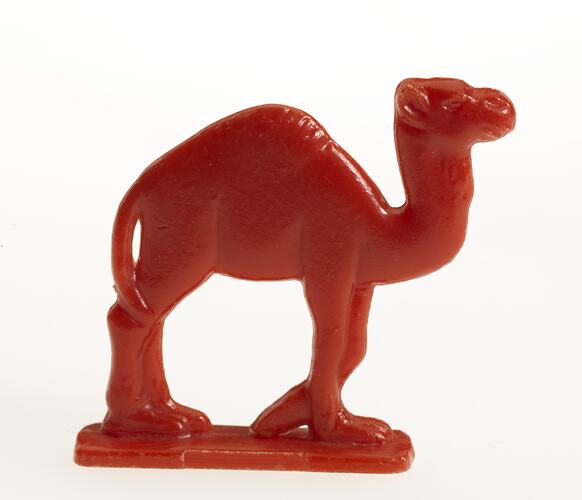 Red plastic toy camel facing right.