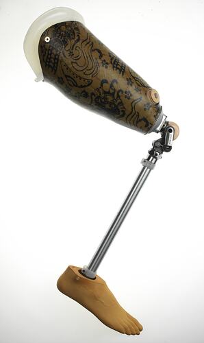 Metal and plastic prosthetic leg with batik style print on thigh,