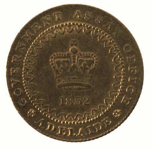 Round coin with raised text around central crown.