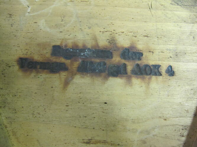 Two lines of text burned into wood.