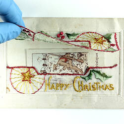 Embroidered postcard with front panel lifted.