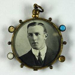Pendant with photo showing man's upper body.