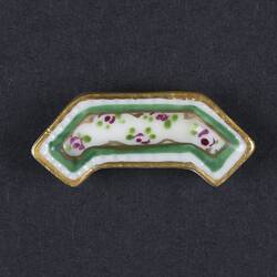 Angular white dish with gold and green edging. Red and green floral motifs in centre.