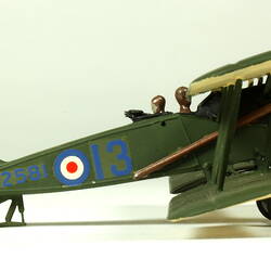 Dark green aeroplane model with red, white, blue circles. Right profile view.