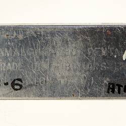 Rectangular metal plate with stamped text.