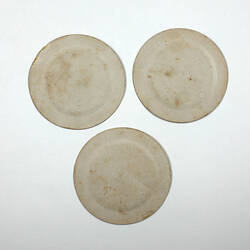 Three round paper plates, reverse side.