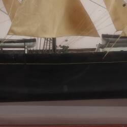 Detail of sailing ship model in glass case, facing right.
