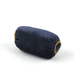 Dark blue cylindrical pillow.