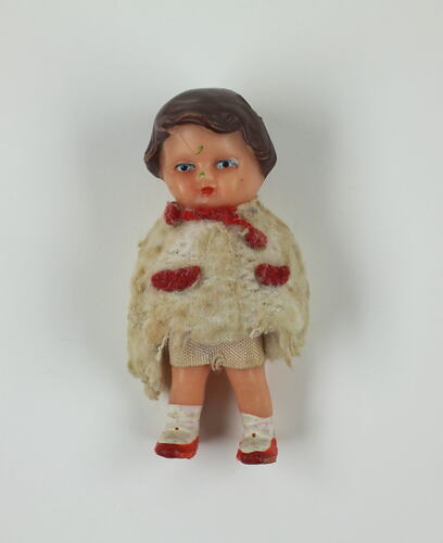 Little boy doll in white jumper.