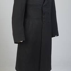 Gentleman's black cotton frock coat, six-button, double-breasted with peaked lapels.