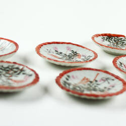 Two rows of Japanese style toy tea set saucers.
