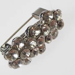 Rectangular brooch with 17 round diamantes. Silver pin on back.