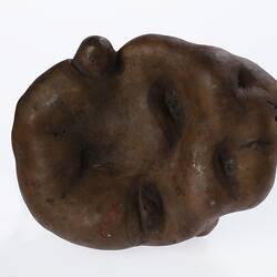 Irregularly shaped brown model of a potato.