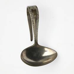 Silver spoon with u-shaped decorative handle. Bowl of the spoon is oval, tapered at one end. Front view.