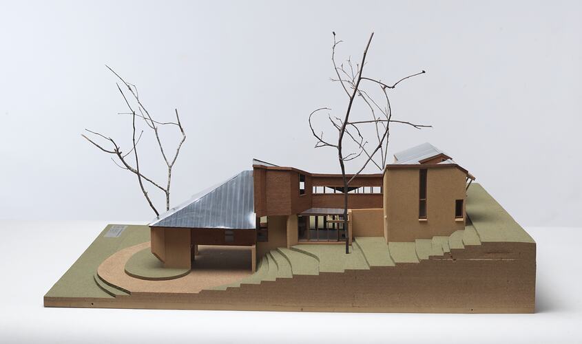 Cork and timber model of brick and timber 5 level house on steep slope. Twigs used as trees. Right profile.