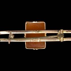 Back of double gold bar with central rectangular reddish-brown cameo. Horizontal pin.