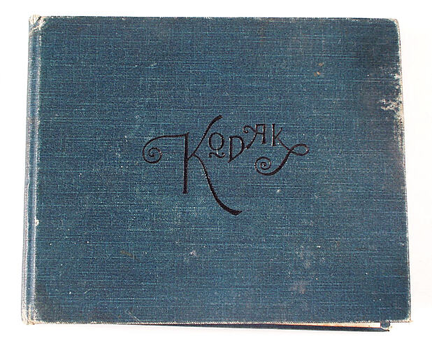 Blue cloth covered album with black cursive text.