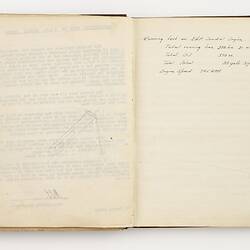 Open book with off white ruled pages. Handwritten text on right page.