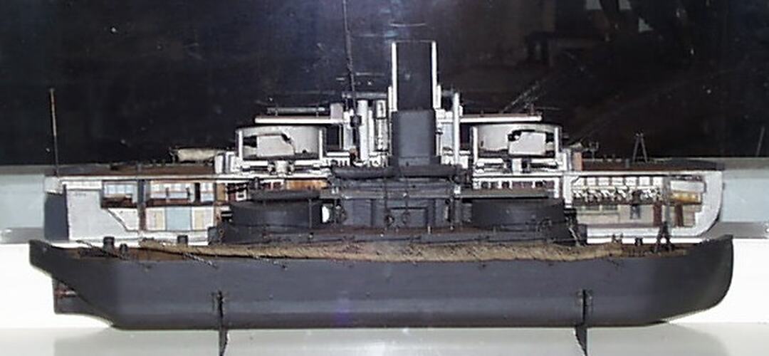 Model of naval warship equipped with turrets, each fitted with two 10-inch rifled muzzle-loading guns.